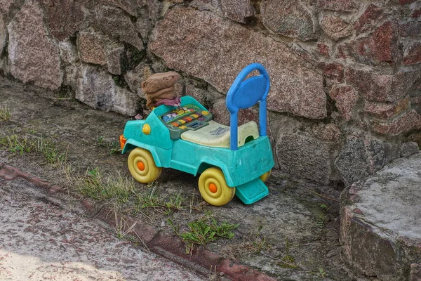 One Toy Plastic Colored Car Bike Stands Grass Gray Stone — Zdjęcie stockowe