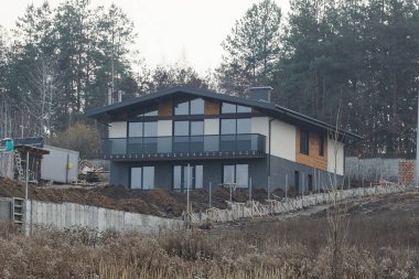 large private gray black house with an open glass balcony outside