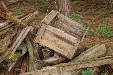 a pile of old gray wooden boards and a broken box on a rural street