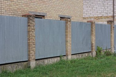 Özel kahverengi gri bir metalin parçası ve sokaktaki duvar çitlerini örüyor.