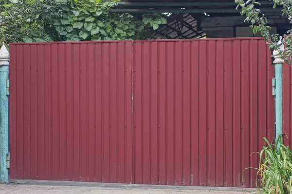 One Large Closed Red Metal Gate Street Green Vegetation — Zdjęcie stockowe
