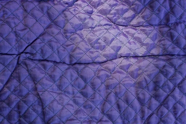 dark purple texture of fabric from a piece of synthetic with a seams