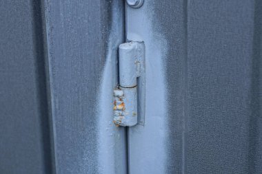 one iron old gray door hinge on a metal gate on a wall in the street