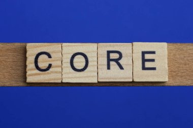 word core made from wooden gray letters lies on a blue background