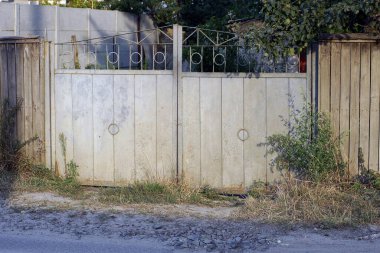 one closed rural metal gate on the fence wall in the street