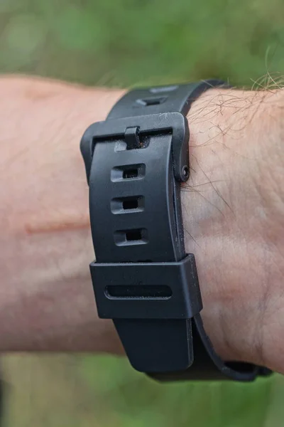 Zwart Gesloten Plastic Horlogeband Een Mans Hand Straat Een Groene — Stockfoto