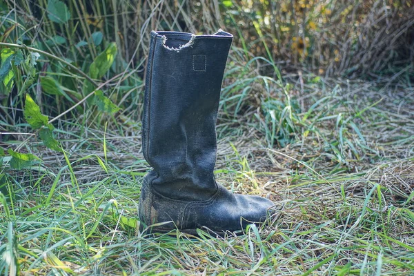 Jeden Stary Czarny Brudny Plandeka Buty Stoi Zielonej Trawie Przyrodzie — Zdjęcie stockowe