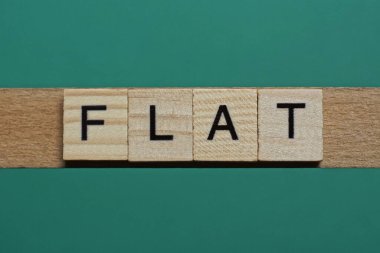 Yeşil kağıt arka planda küçük gri ahşap harflerden oluşan düz bir kelime.