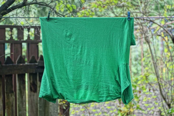 Jedno Tričko Zelené Látky Visí Drátu Ulici Mezi Vegetací — Stock fotografie