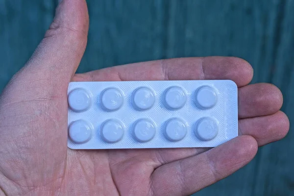 Mano Sosteniendo Una Ampolla Plástico Blanco Con Pastillas Sobre Fondo — Foto de Stock