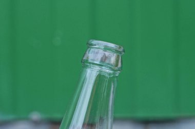 Yeşil arka planda beyaz cam şişenin birinci kısmı.