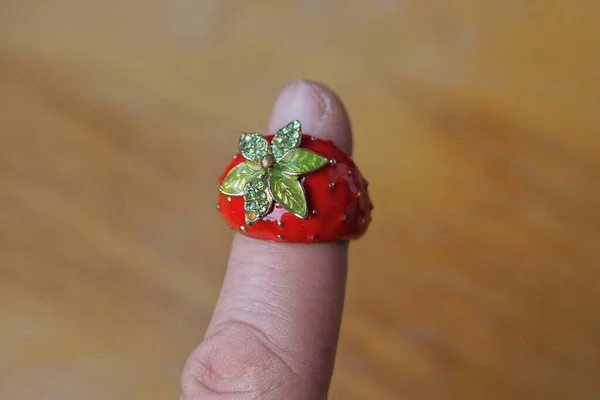 Jeden Duży Metalowy Pierścień Postaci Czerwonej Truskawki Zielonymi Liśćmi Palcu — Zdjęcie stockowe