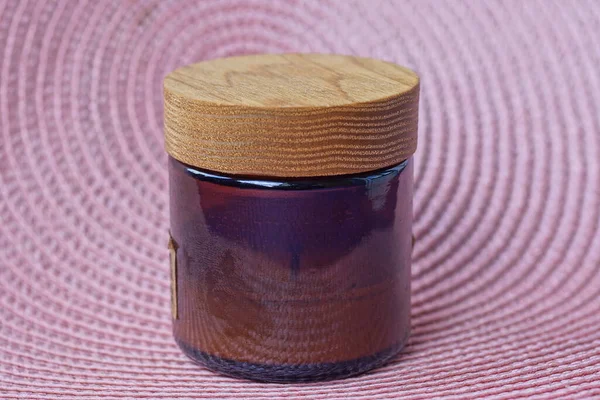 Jeden Brązowy Szklany Słoik Świecą Zapachową Zamkniętą Drewnianą Pokrywą Stoi — Zdjęcie stockowe
