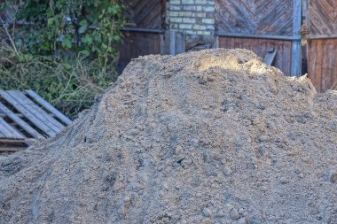 Duvara karşı caddede kahverengi bir kum yığını