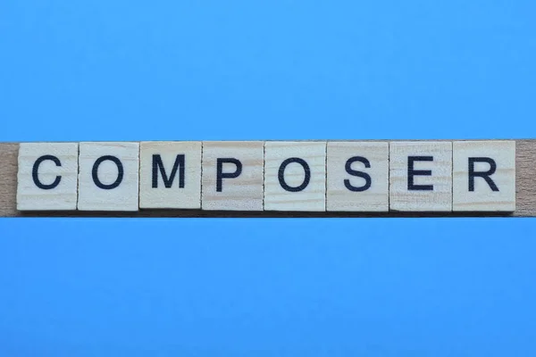 Wortkomponist Aus Grauen Holzbuchstaben Liegt Auf Blauem Hintergrund — Stockfoto