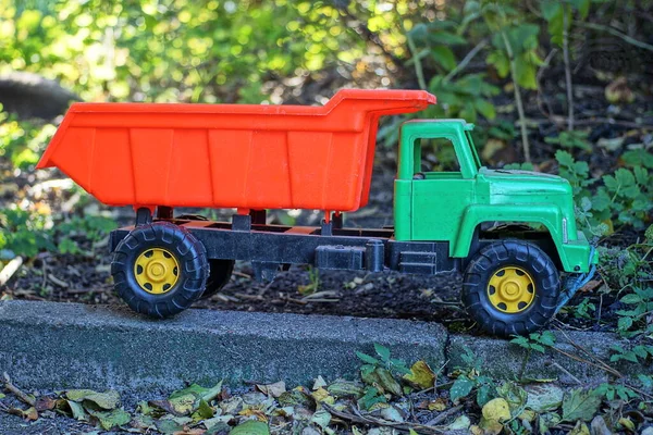 Jeden Duży Plastikowy Samochód Zabawki Zieloną Kabiną Czerwony Korpus Stoi — Zdjęcie stockowe