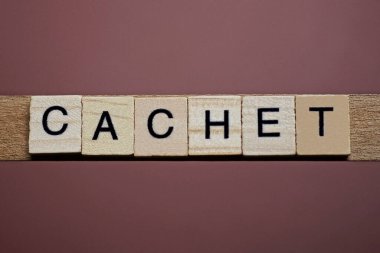  Kahverengi arkaplandaki ahşap kare harflerden yapılmış gri sözcüğü.