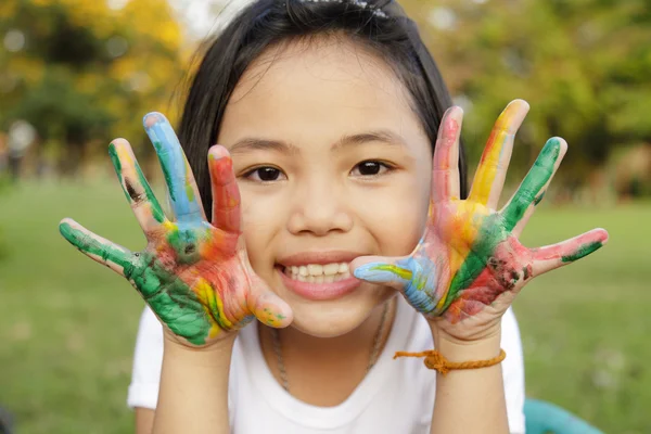 Asiatica bambina con le mani dipinte in vernici colorate — Foto Stock