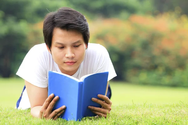 Genç adam kitap okuyor. — Stok fotoğraf