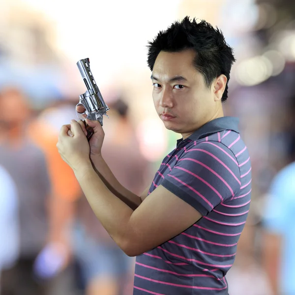 Uomo in possesso di pistola su sfondo bianco — Foto Stock