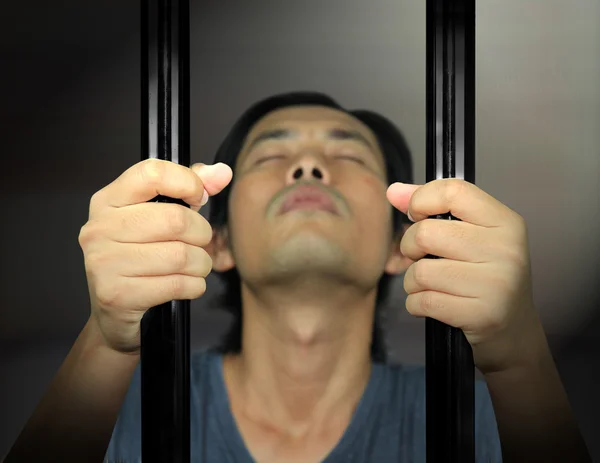 Mãos de homem do preso em uma treliça de aço — Fotografia de Stock