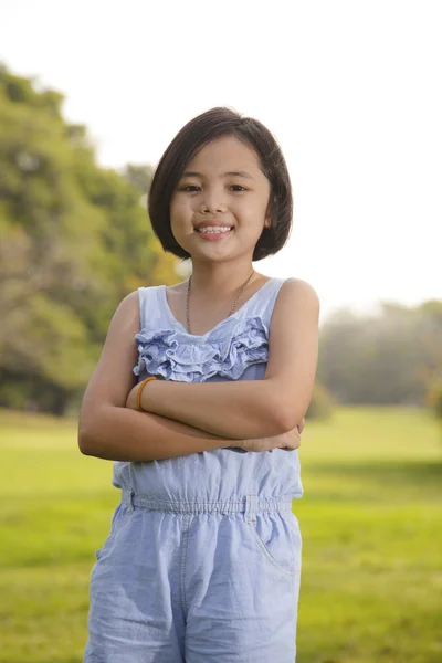 Asiatisches kleines Mädchen lächelt glücklich im Park — Stockfoto