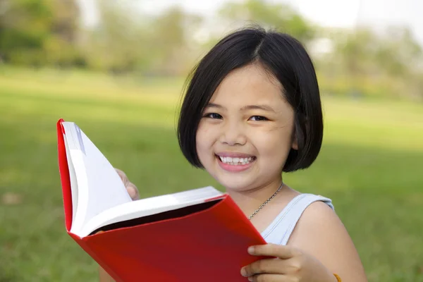 Asiático menina leitura livro no parque — Fotografia de Stock