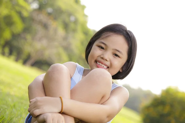 Азиатская маленькая девочка счастливо улыбается в парке — стоковое фото