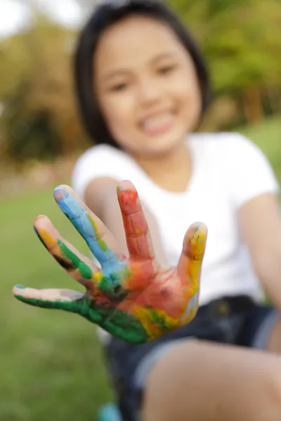 Asiatique petite fille avec les mains peintes dans des peintures colorées — Photo