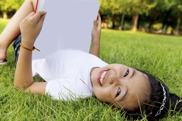 Asyalı küçük kız rahatla ve park kitap okuma — Stok fotoğraf