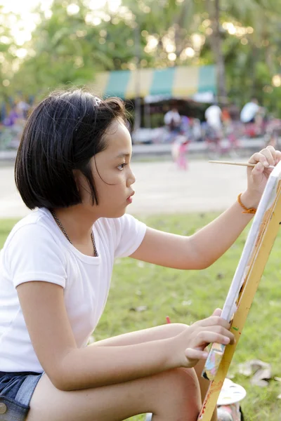 Азиатская маленькая девочка рисует в парке — стоковое фото