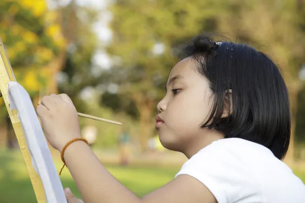 Asian little girl painting in in the park — Stock Photo, Image