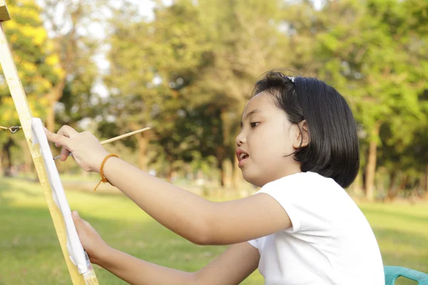 Азиатская маленькая девочка рисует в парке — стоковое фото