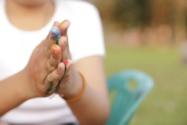 Asian little girl with hands painted in colorful paints — Stock Photo, Image