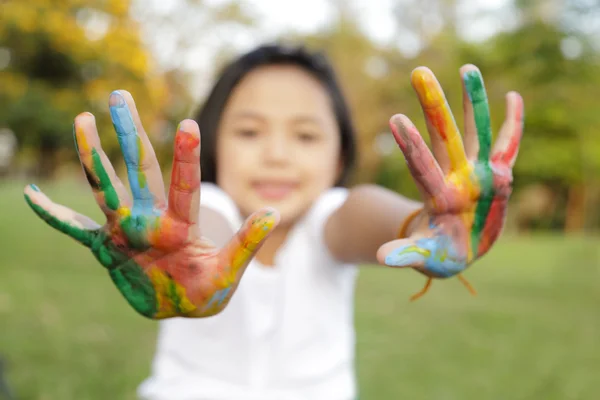 Asiatique petite fille avec les mains peintes dans des peintures colorées — Photo