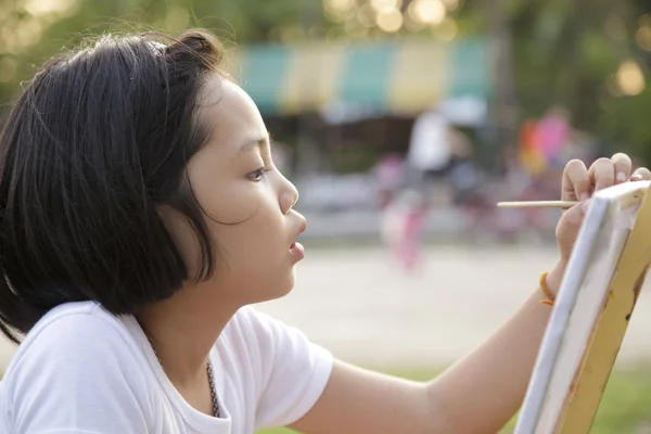 Asian little girl painting in in the park — Stock Photo, Image