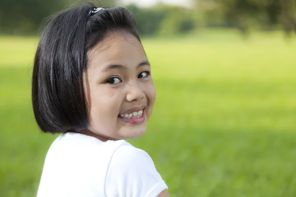 Ragazza asiatica rilassarsi e sorridere felicemente nel parco — Foto Stock