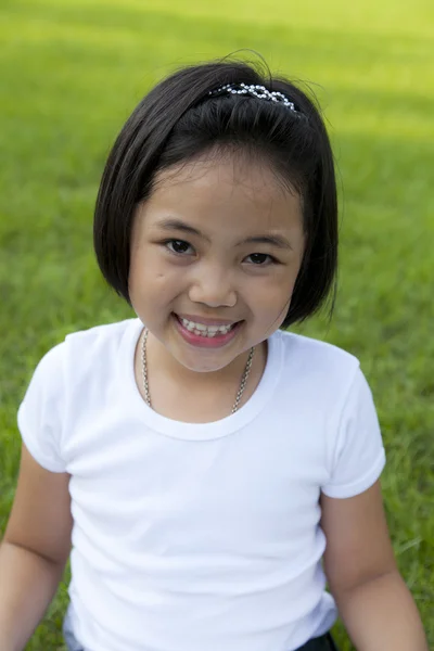 Ragazza asiatica rilassarsi e sorridere felicemente nel parco — Foto Stock