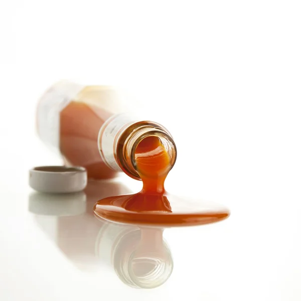 Bottle of chili sauce poured on a white background. — Stock Photo, Image