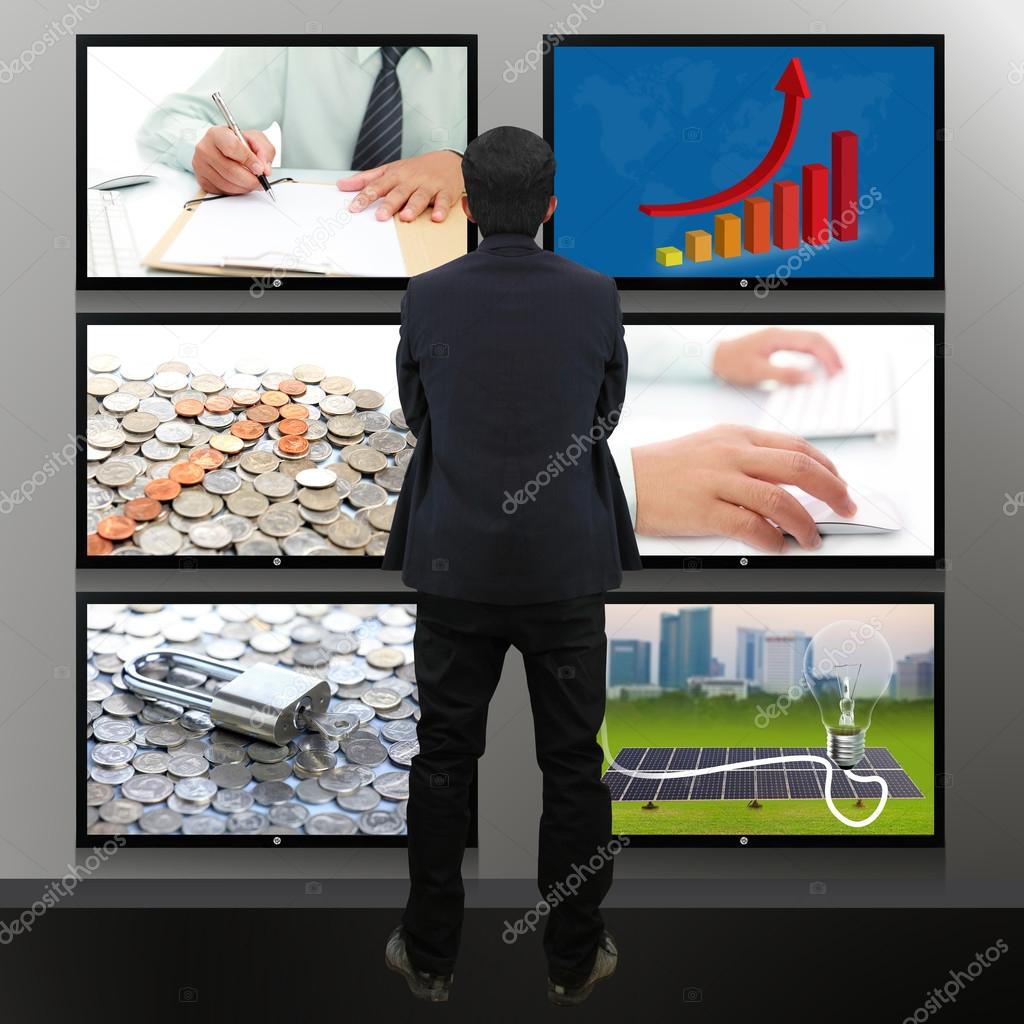 Businessman standing looking at the TV screen