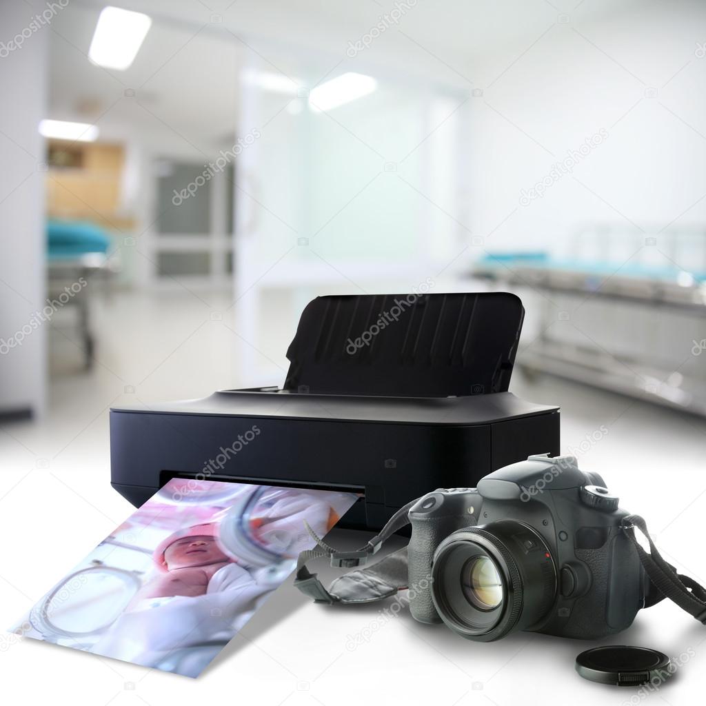 Camera and printer with picture of a newborn baby in the hospita