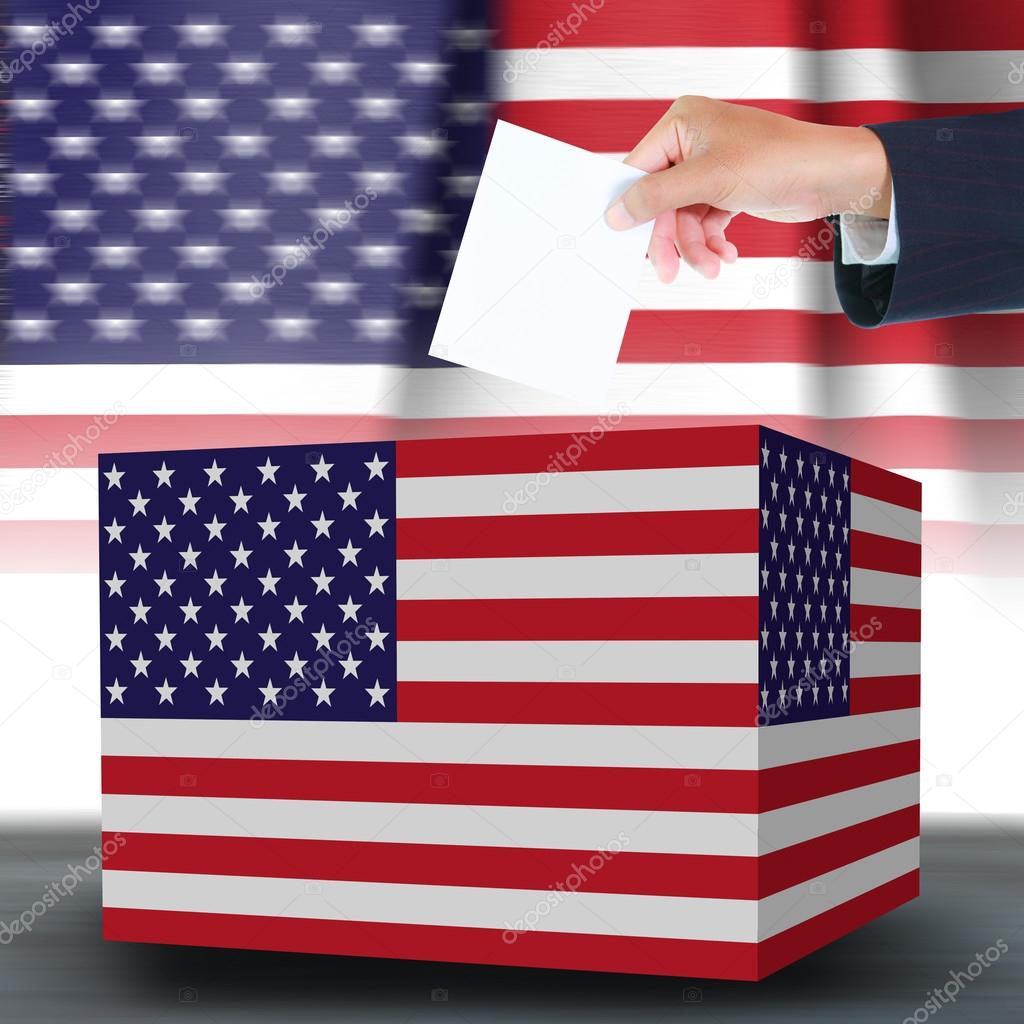 Hand holding ballot and box with the USA flag in the background