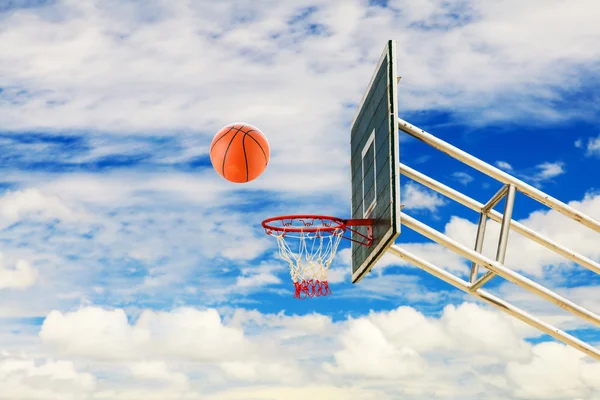 Баскетбольная корзина и мяч на голубом небе — стоковое фото