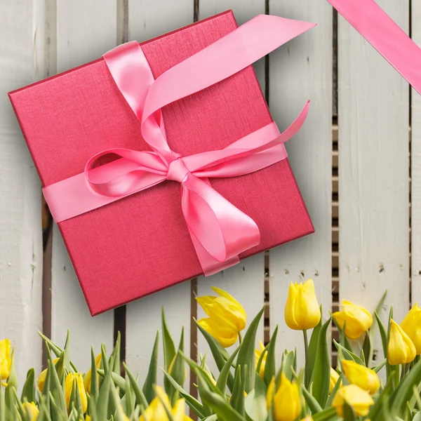 Красная подарочная коробка с желтыми тюльпанами — стоковое фото