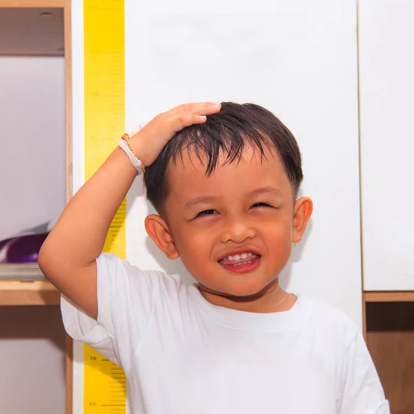 Pequeño niño midiendo su altura —  Fotos de Stock