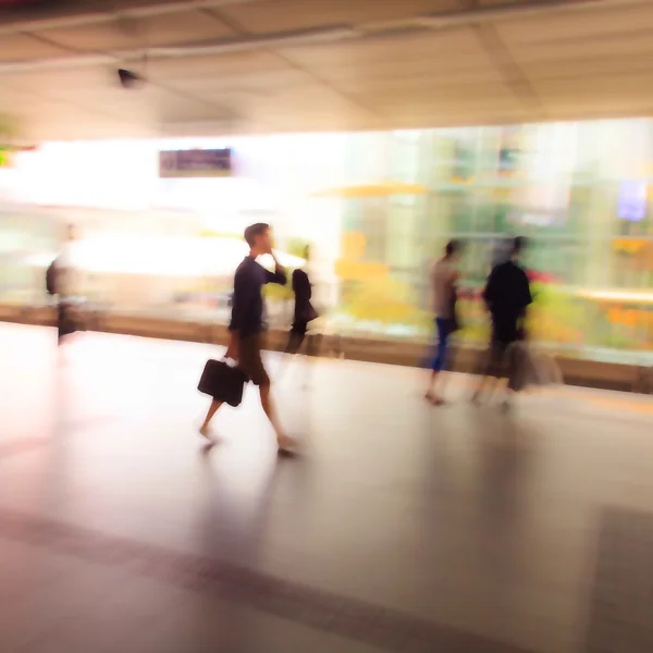 La gente de la ciudad caminando en la estación de skytrain en desenfoque movimiento — Foto de Stock