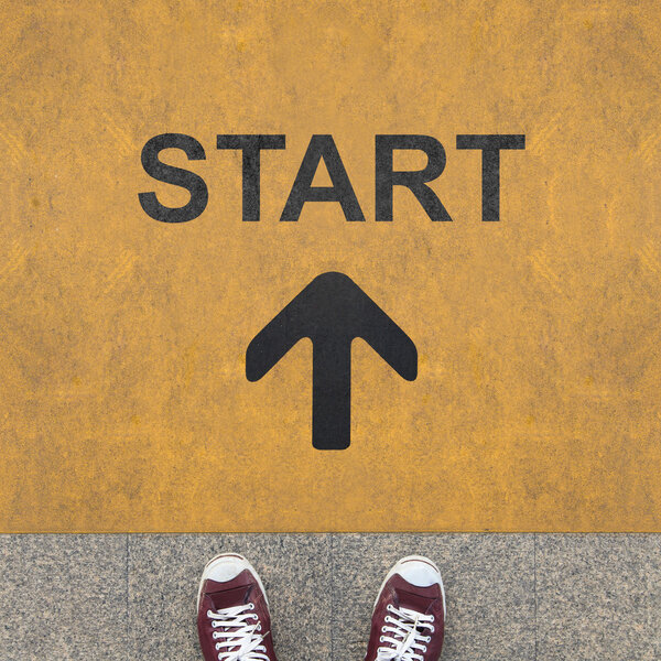 Стрелка старта на желтом фоне
