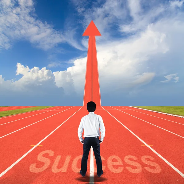 Бизнесмен с успехом стоит на беговой дорожке — стоковое фото