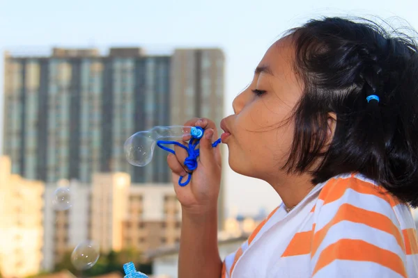 Little girl is blowing bubbles — Stock Photo, Image