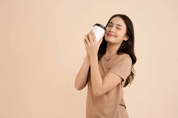 Szczęśliwa Młoda Kobieta Trzyma Filiżankę Kawy Stojąc Brązowym Tle Studio — Zdjęcie stockowe